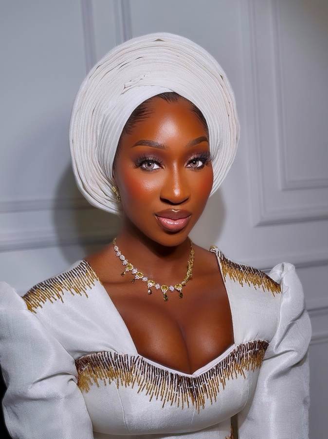 Client in a white gele with beaded gold-fringe gown